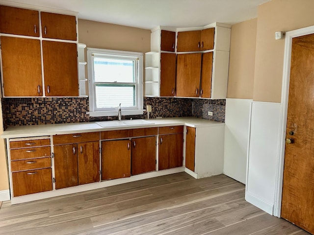 kitchen featuring a sink, open shelves, and brown cabinets