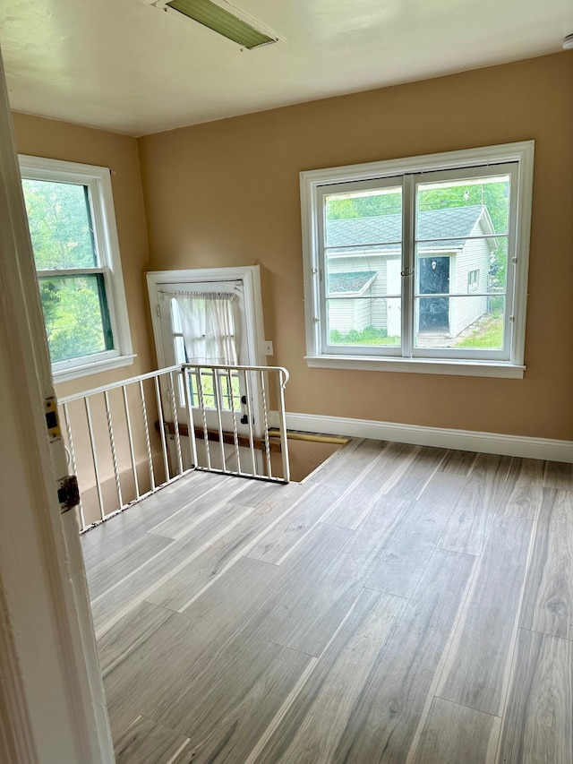 spare room with wood finished floors and baseboards