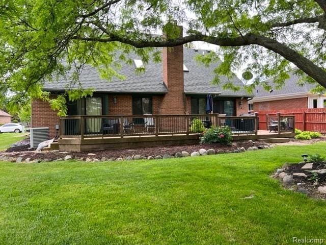 15743 Greenview, Fraser, MI 48026 - back of property featuring brick siding, a deck, a chimney, and a lawn