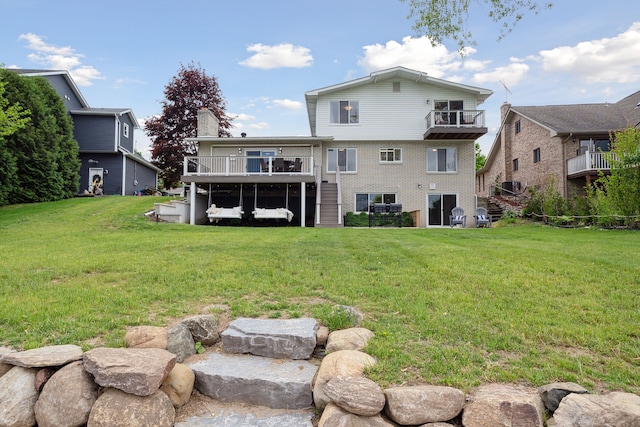 3732 Loch Dr, Highland, MI 48357 - rear view of property featuring stairway, brick siding, a lawn, and a deck