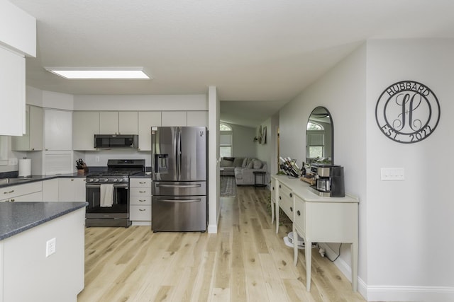 9561 Springville Hwy, Onsted, MI 49265 - kitchen featuring appliances with stainless steel finishes, dark countertops, light wood-type flooring, and baseboards
