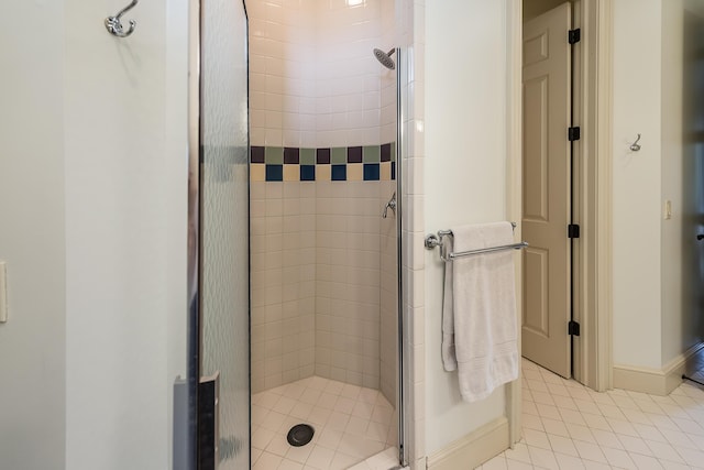 full bathroom featuring a shower stall, tile patterned floors, and baseboards