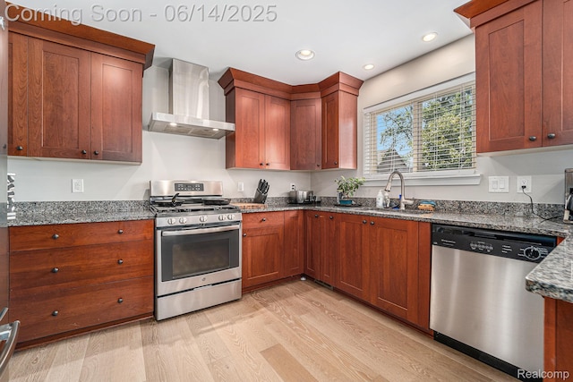 4715 Mandalay Ave, Royal Oak, MI 48073 - kitchen with stainless steel appliances, wall chimney range hood, light wood-style floors, dark stone countertops, and brown cabinetry