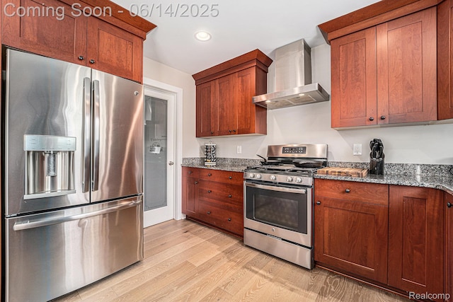4715 Mandalay Ave, Royal Oak, MI 48073 - kitchen featuring stainless steel appliances, wall chimney range hood, light wood finished floors, dark stone counters, and brown cabinets