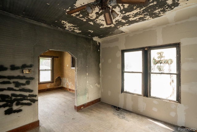 17257 Moenart St, Hamtramck, MI 48212 - empty room with ceiling fan, arched walkways, wood finished floors, and baseboards