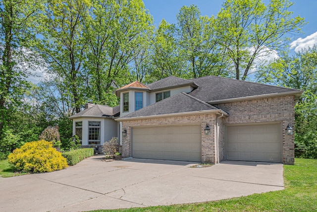 1506 Golfside Ct, Flushing, MI 48433 - view of front of home with a garage, driveway, a shingled roof, stucco siding, and brick siding