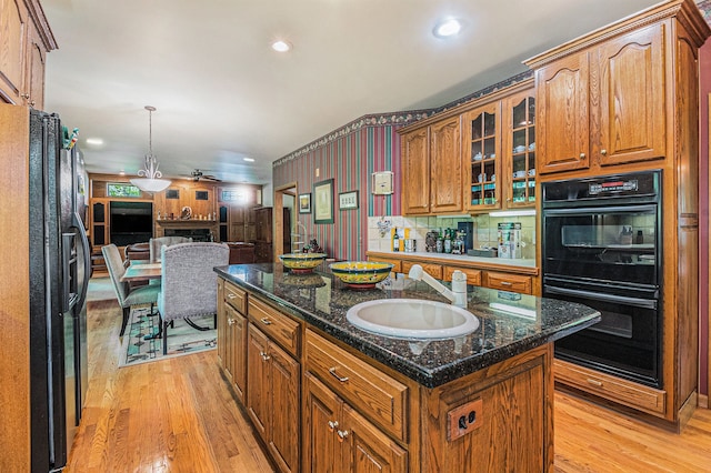 1506 Golfside Ct, Flushing, MI 48433 - kitchen with black appliances, a sink, open floor plan, a kitchen island, and light wood finished floors