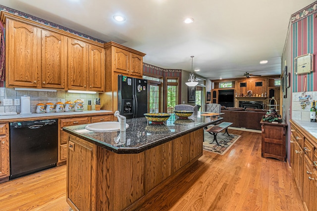 1506 Golfside Ct, Flushing, MI 48433 - kitchen featuring black appliances, a sink, open floor plan, brown cabinetry, and light wood-style flooring