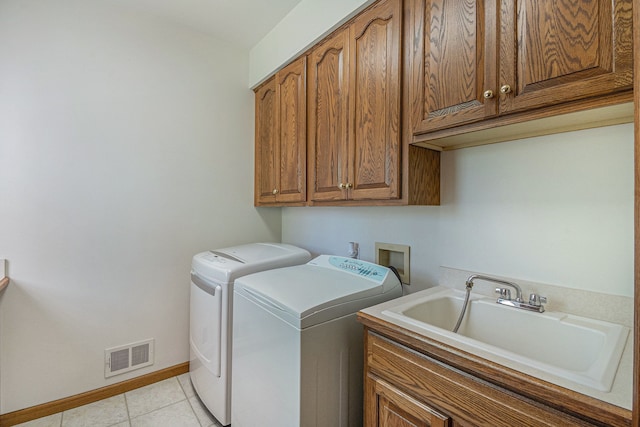 1506 Golfside Ct, Flushing, MI 48433 - washroom featuring separate washer and dryer, cabinet space, light tile patterned floors, and baseboards
