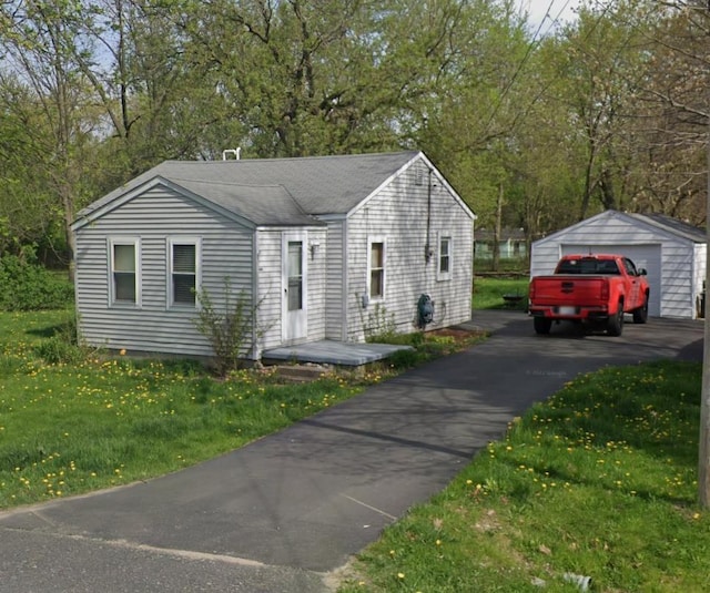 1038 W Pine Ave, Mount Morris, MI 48458 - view of front facade featuring a detached garage, a front yard, and an outdoor structure