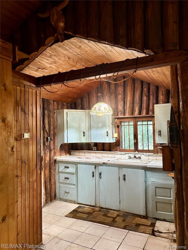 3788 Cedar Point Rd, Howell, MI 48843 - kitchen with wooden walls, tile counters, wooden ceiling, and light tile patterned floors