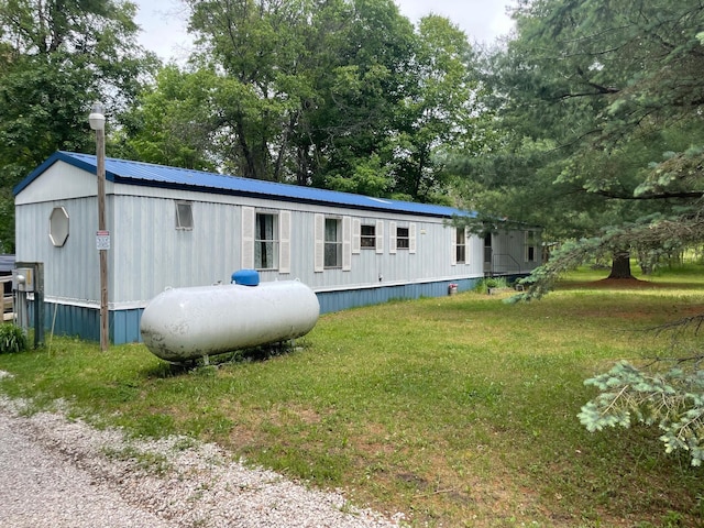 21576 Caberfae Hwy, Wellston, MI 49689 - view of front of property featuring a front yard, metal roof, and view of wooded area
