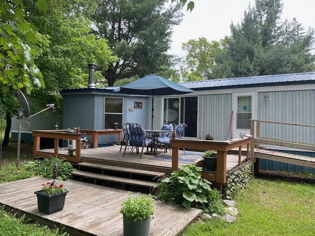 21576 Caberfae Hwy, Wellston, MI 49689 - back of property with outdoor dining area, metal roof, and a deck