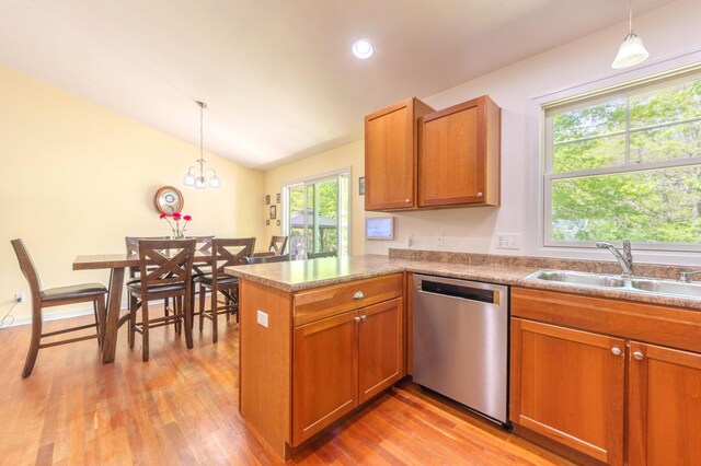 1373 Kristen Path, Saint Joseph, MI 49085 - kitchen with stainless steel dishwasher, a sink, brown cabinets, light wood-type flooring, and vaulted ceiling