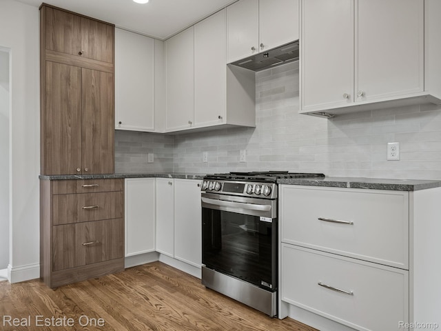 1149 Larkmoor Blvd, Berkley, MI 48072 - kitchen featuring stainless steel range with gas stovetop, under cabinet range hood, dark countertops, light wood finished floors, and white cabinets