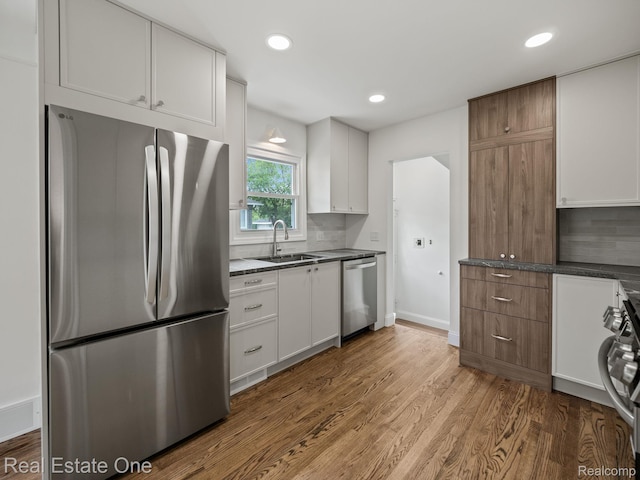 1149 Larkmoor Blvd, Berkley, MI 48072 - kitchen featuring appliances with stainless steel finishes, a sink, wood finished floors, dark countertops, and white cabinetry