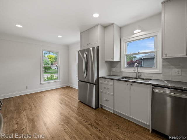 1149 Larkmoor Blvd, Berkley, MI 48072 - kitchen with appliances with stainless steel finishes, a sink, decorative backsplash, dark wood-type flooring, and baseboards