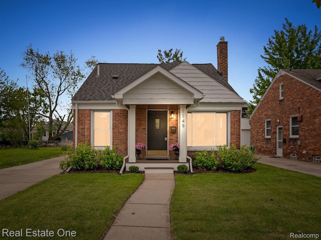 1149 Larkmoor Blvd, Berkley, MI 48072 - view of front of house featuring a front yard, a shingled roof, a chimney, and brick siding