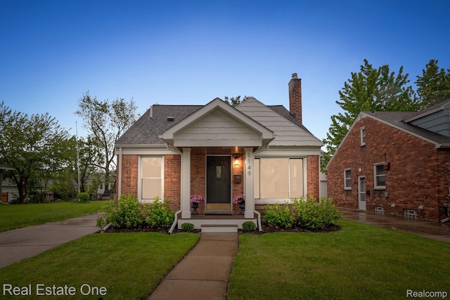 1149 Larkmoor Blvd, Berkley, MI 48072 - view of front of property featuring a front yard, a chimney, and brick siding