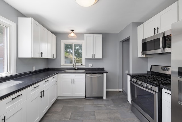 22637 Karam Ct, Warren, MI 48091 - kitchen with appliances with stainless steel finishes, a sink, white cabinetry, dark countertops, and baseboards