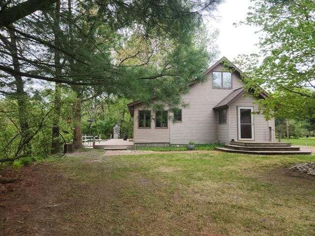 9332 W 10 Mile Rd, Irons, MI 49644 - back of house featuring a deck and a lawn