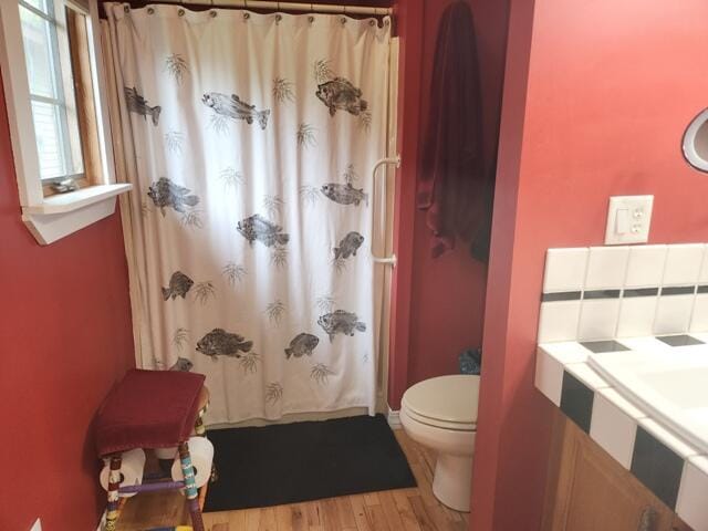 9332 W 10 Mile Rd, Irons, MI 49644 - full bathroom featuring toilet, wood finished floors, and curtained shower