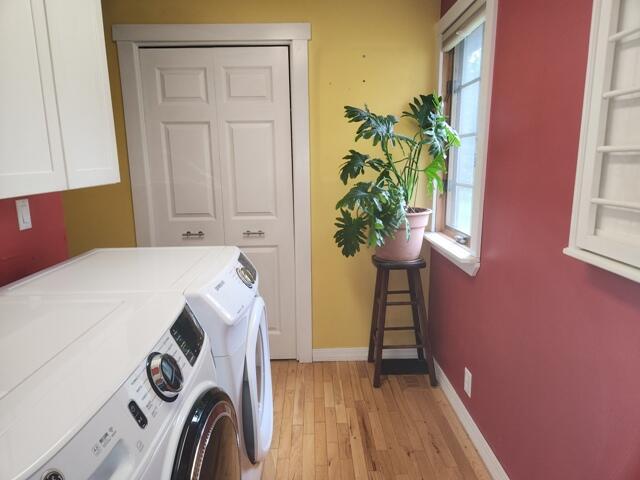 9332 W 10 Mile Rd, Irons, MI 49644 - laundry room with independent washer and dryer, cabinet space, light wood-type flooring, and baseboards