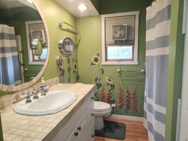 9332 W 10 Mile Rd, Irons, MI 49644 - full bath with toilet, wood finished floors, vanity, a shower with shower curtain, and baseboards