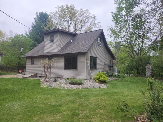 9332 W 10 Mile Rd, Irons, MI 49644 - view of side of home with a yard and a shingled roof