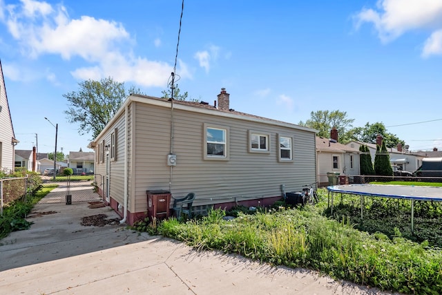 13722 Birrell St, Southgate, MI 48195 - rear view of house featuring a chimney and a trampoline