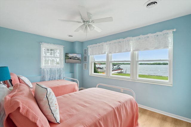 3761 Hunt Rd, Lapeer, MI 48446 - bedroom featuring wood finished floors, baseboards, a water view, and a ceiling fan