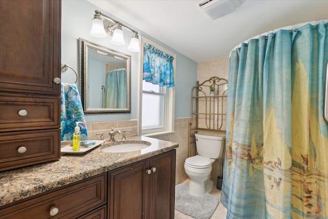 3761 Hunt Rd, Lapeer, MI 48446 - full bathroom featuring tile walls, toilet, vanity, and wainscoting