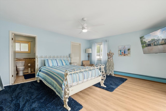 3761 Hunt Rd, Lapeer, MI 48446 - bedroom featuring a baseboard radiator, connected bathroom, ceiling fan, and wood finished floors