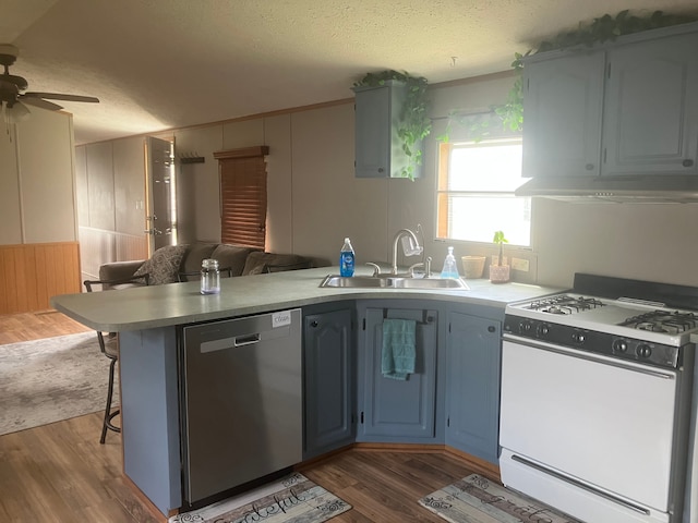 515 E Pond Vw, Morrice, MI 48857 - kitchen featuring white range with gas cooktop, dishwasher, a sink, under cabinet range hood, and a peninsula