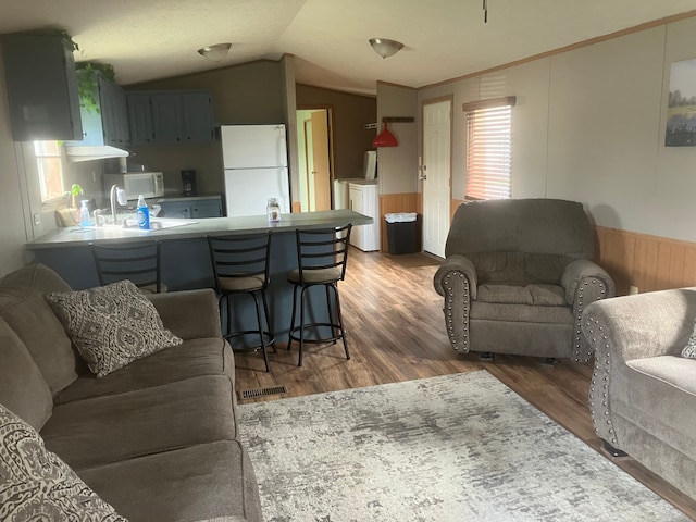 515 E Pond Vw, Morrice, MI 48857 - living area featuring vaulted ceiling, wood finished floors, wainscoting, wood walls, and ornamental molding