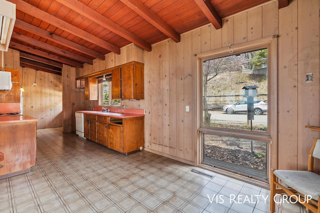 17933 N Shore Estates Rd, Spring Lake, MI 49456 - kitchen with wooden walls, light flooring, wooden ceiling with exposed beams, light countertops, and white dishwasher