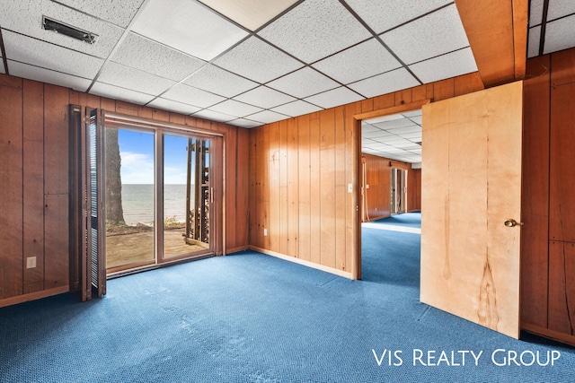 17933 N Shore Estates Rd, Spring Lake, MI 49456 - carpeted empty room with wooden walls, a water view, baseboards, and a paneled ceiling