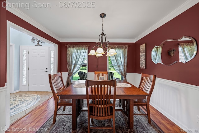 9863 Marshall Rd, South Lyon, MI 48178 - dining space with a chandelier, ornamental molding, wood finished floors, and a wainscoted wall
