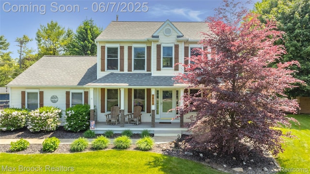 9863 Marshall Rd, South Lyon, MI 48178 - view of front of house with covered porch, a front lawn, and a shingled roof