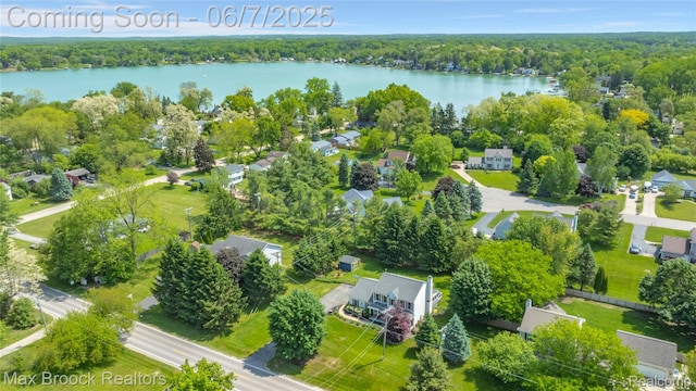 9863 Marshall Rd, South Lyon, MI 48178 - aerial perspective of suburban area with a nearby body of water and a heavily wooded area