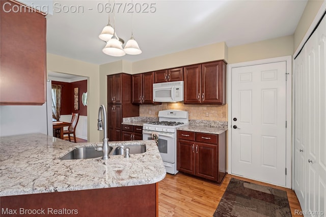 9863 Marshall Rd, South Lyon, MI 48178 - kitchen with white appliances, a sink, light wood finished floors, pendant lighting, and decorative backsplash