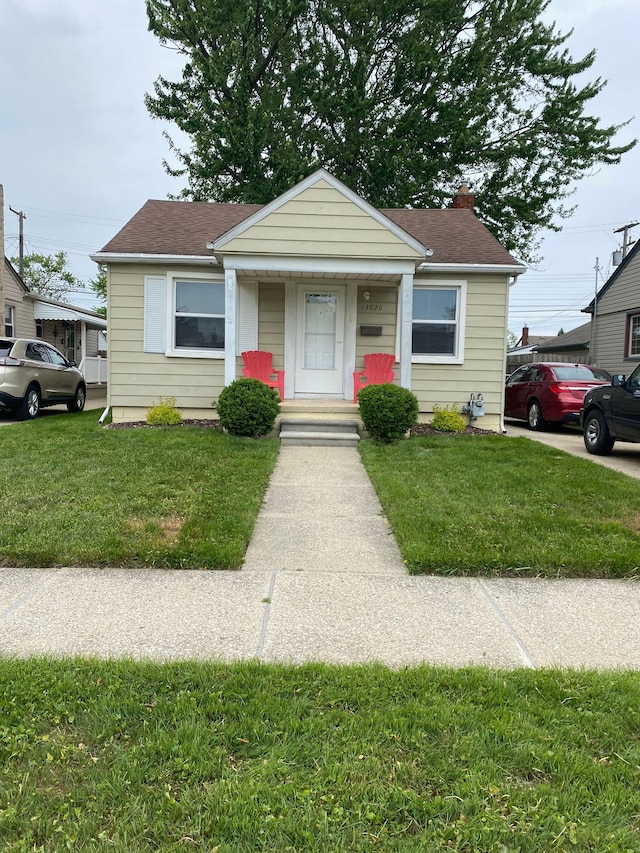 13020 Castle St, Southgate, MI 48195 - bungalow-style house featuring a front yard, roof with shingles, and covered porch