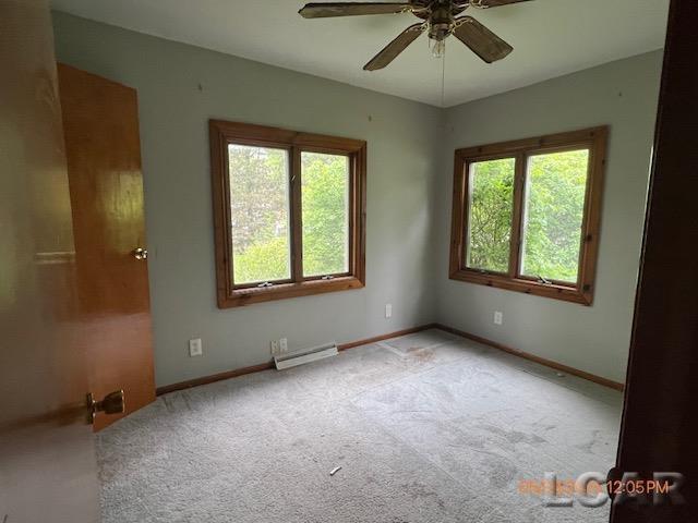 6730 Summerfield Rd, Temperance, MI 48182 - carpeted spare room featuring plenty of natural light, a baseboard heating unit, a ceiling fan, and baseboards