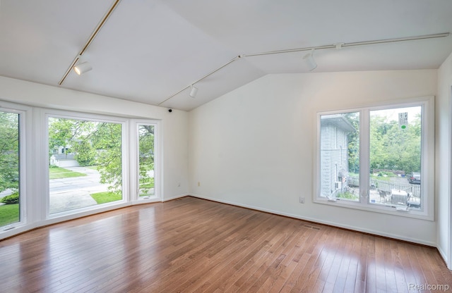 2264 W Maple Rd, Bloomfield Hills, MI 48301 - spare room featuring rail lighting, hardwood / wood-style floors, vaulted ceiling, and baseboards