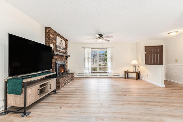 7719 Guenthardt Rd, Manistee, MI 49660 - unfurnished living room with light wood finished floors, a ceiling fan, a baseboard radiator, and a fireplace
