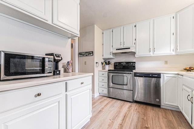 7719 Guenthardt Rd, Manistee, MI 49660 - kitchen with appliances with stainless steel finishes, under cabinet range hood, light wood-style floors, white cabinets, and light countertops