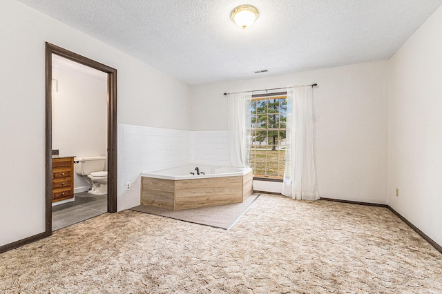 7719 Guenthardt Rd, Manistee, MI 49660 - unfurnished bedroom featuring light colored carpet, a textured ceiling, and connected bathroom