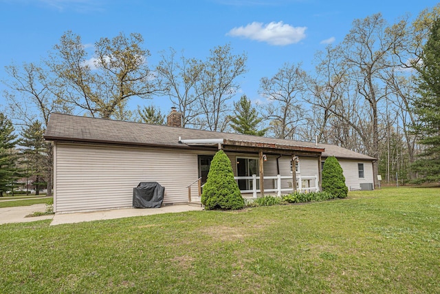 7719 Guenthardt Rd, Manistee, MI 49660 - back of property featuring a yard, a chimney, and a patio
