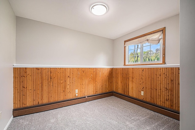 823 W Park Dr, Niles, MI 49120 - empty room featuring wood walls, carpet, wainscoting, and a baseboard heating unit
