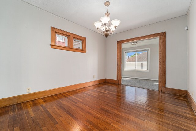50 Elm St, River Rouge, MI 48218 - unfurnished room featuring a chandelier, baseboards, and wood-type flooring